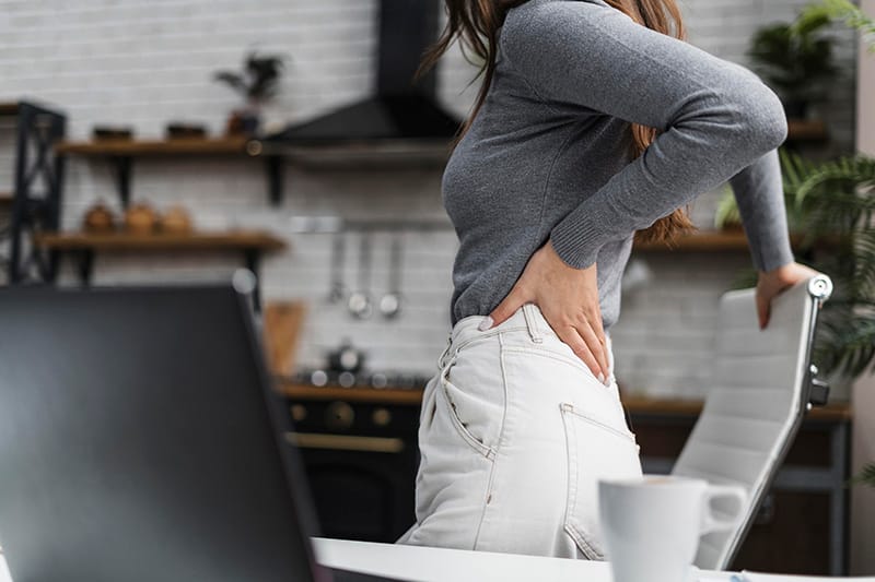 side view woman having backache while working from homejpg