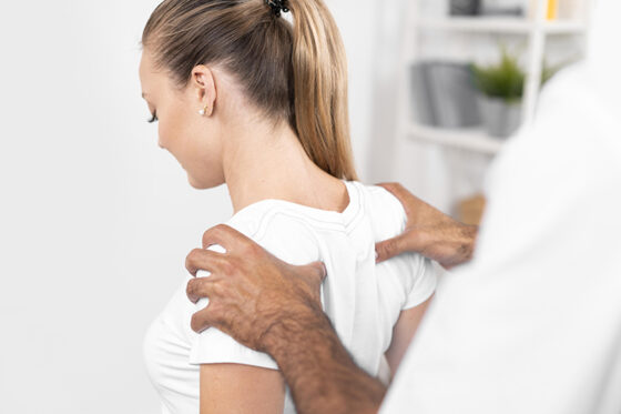 male physiotherapist checking woman s back shoulders 560x373.jpg